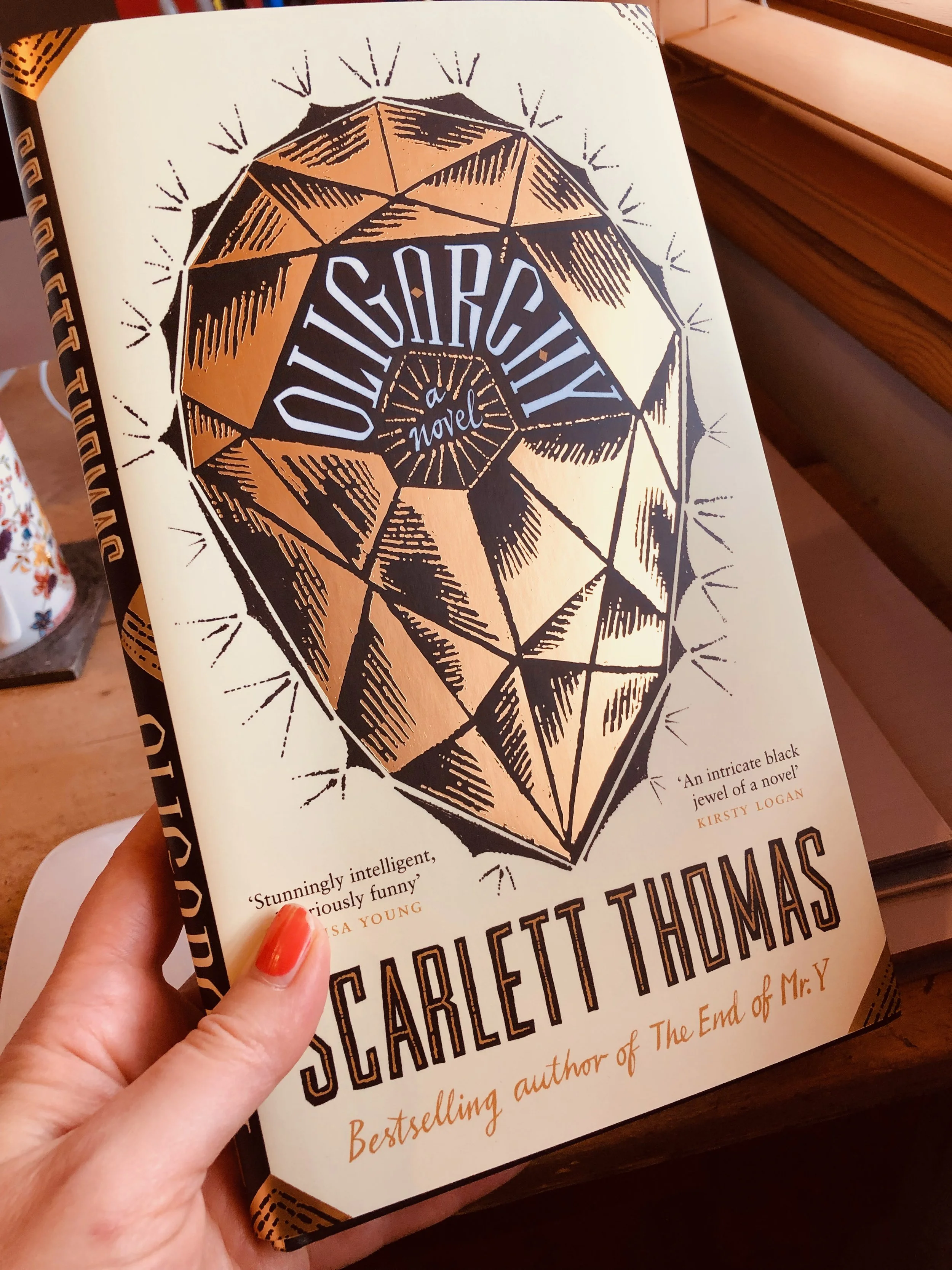 Front cover of the book titled "Ongoing City: A novel" by Scarlett Thomas, featuring a large stylized illustration of a gemstone.