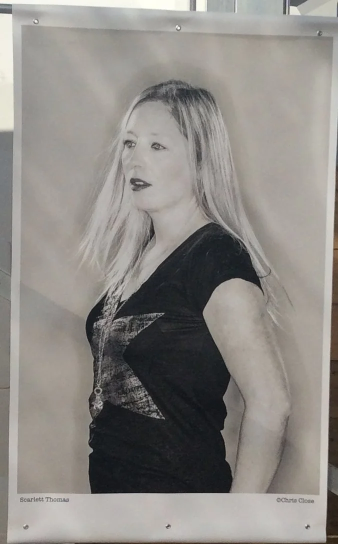 Black and white portrait of a woman with long straight hair, wearing a black t-shirt with a star design. She is looking to her left with a neutral expression.
