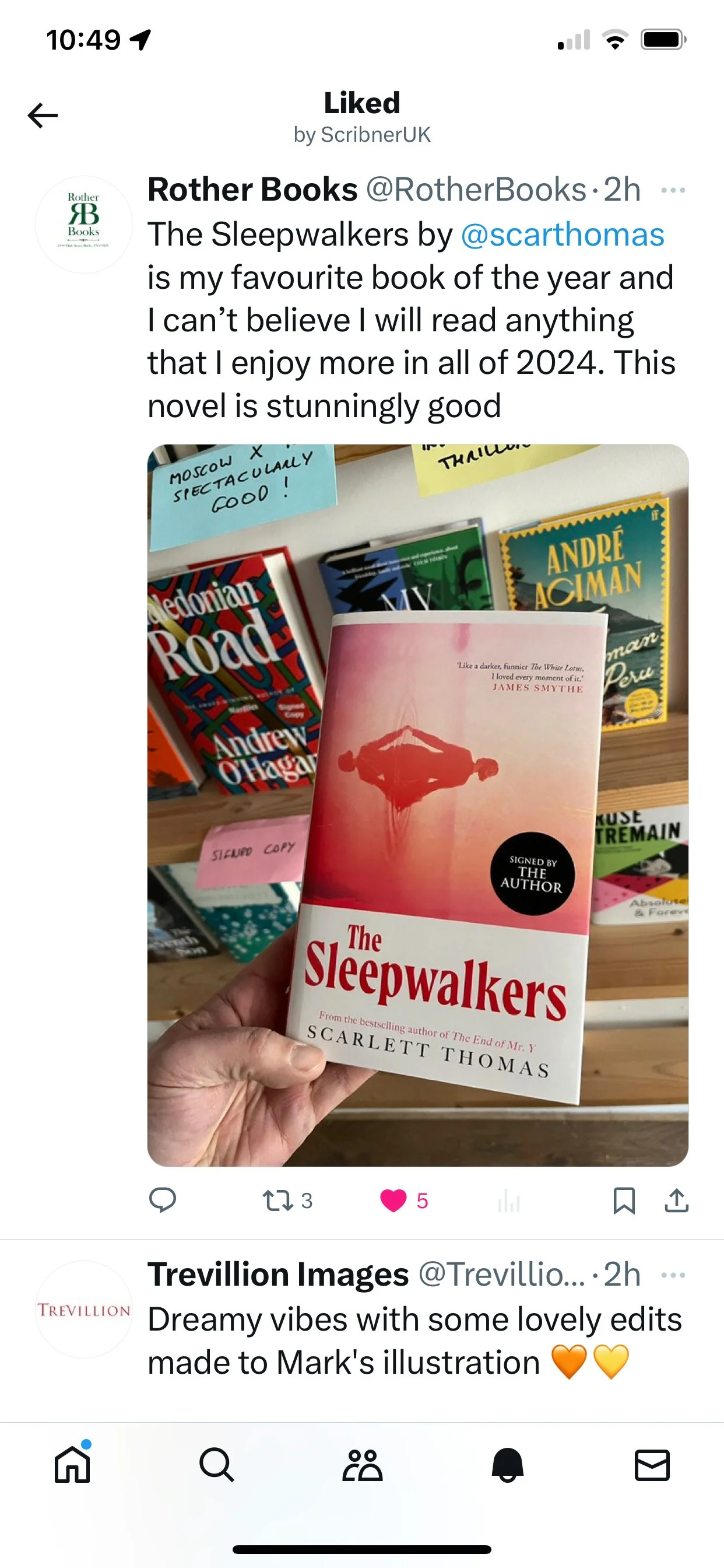 Close-up of a person holding a book titled 'The Sleepwalkers' by Scarlett Thomas in a bookstore. Other books are visible in the background on a shelf.