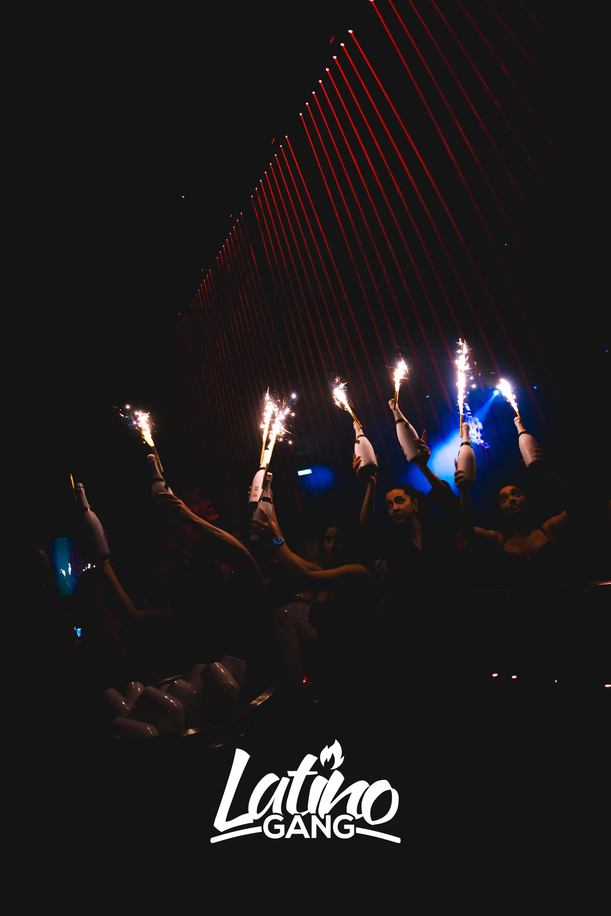 Menschen im Club feiern mit Flaschen, die Funken sprühen, im Dunkeln, mit Lichterketten