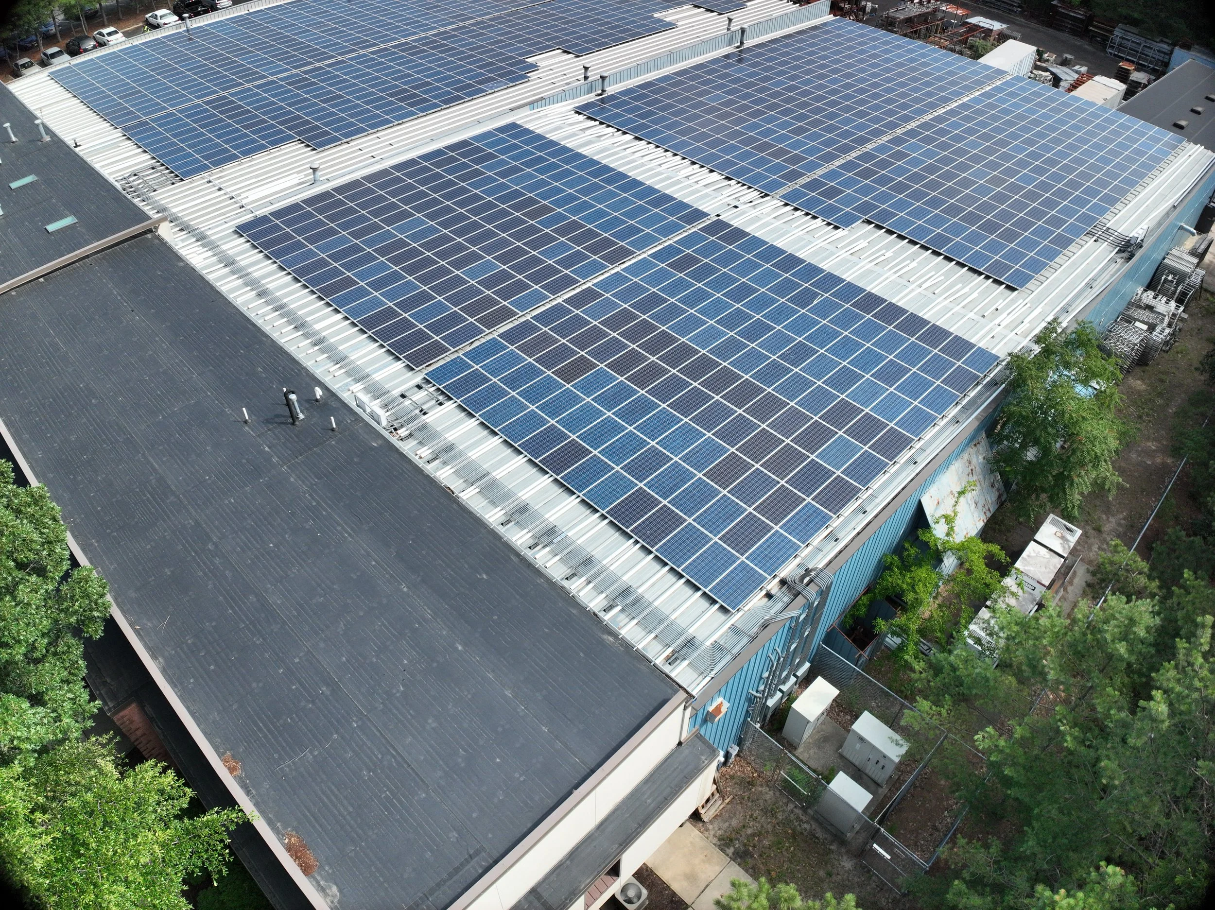 A large commercial building with a roof covered in solar panels.