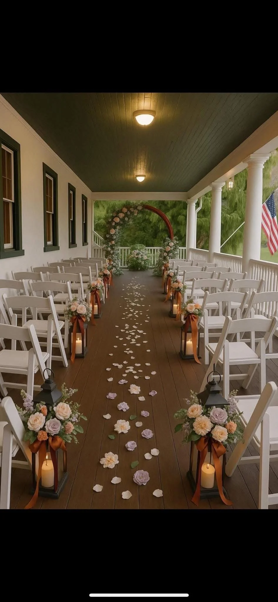 Decorated outdoor porch arranged for a wedding ceremony with white chairs, floral arrangements, lanterns, candles, and rose petal aisle.