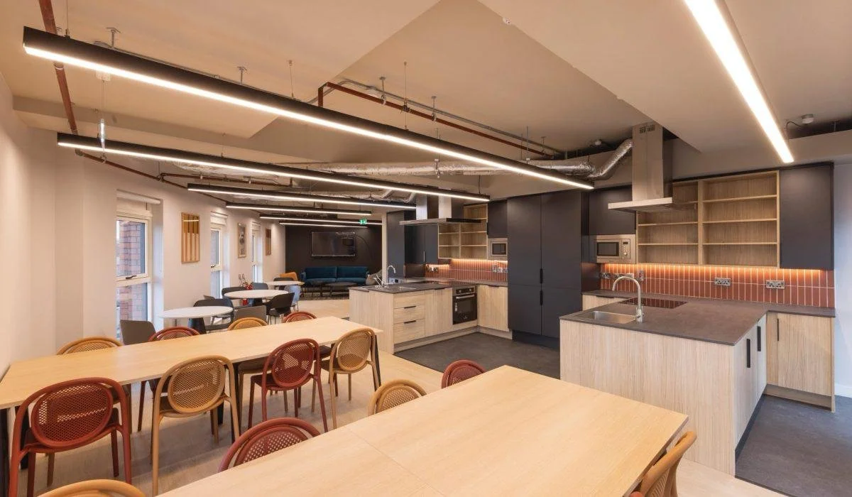Modern kitchen and dining area with multiple tables, chairs, and an open-concept layout.