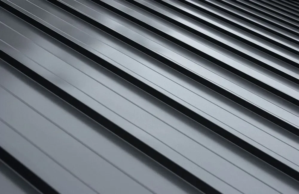 Close-up of metallic, parallel, grooved surfaces, likely part of an industrial or architectural structure.