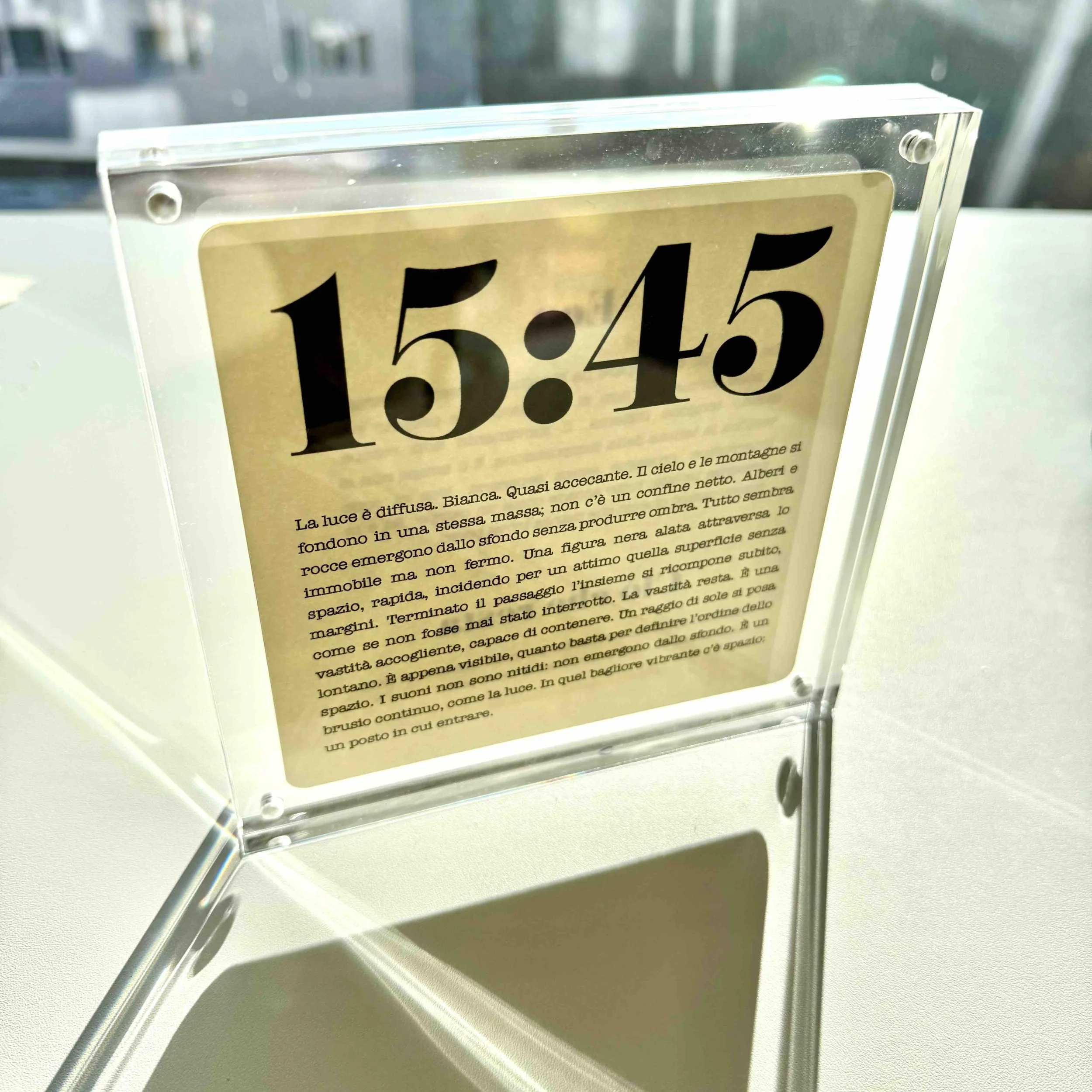 Segnaletica da tavolo con orario 15:45 e testo descrittivo in italiano