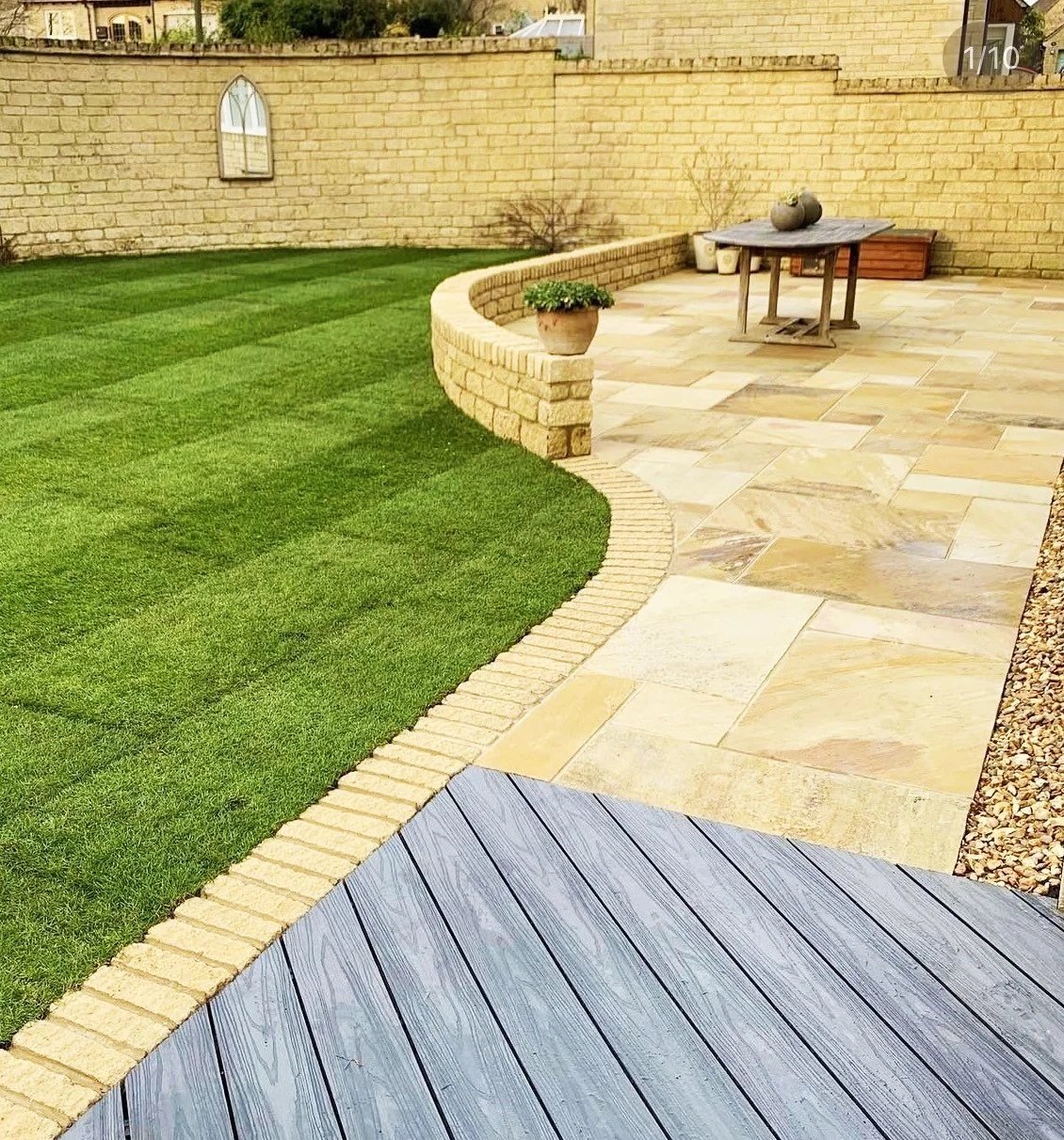 A complete redesign with - composite deck, stone slabs, turf and curved stone walling.