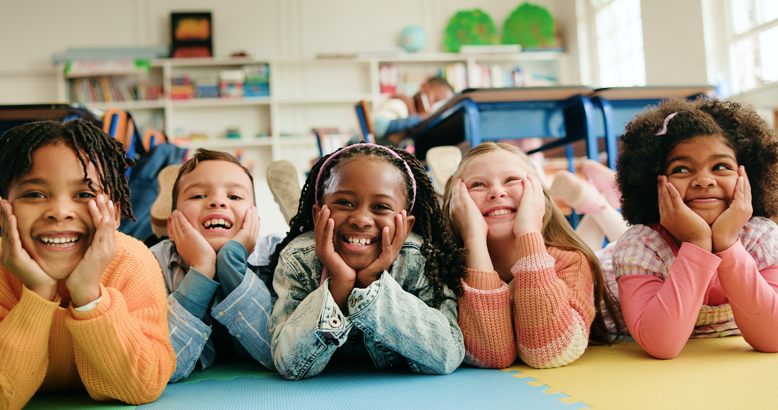 classroom-happy-kids-students-floor-learning-diversity-elementary-school-children-boys-group-girls-laugh-with-friends-education-future-development-smile-with-portrait.jpg