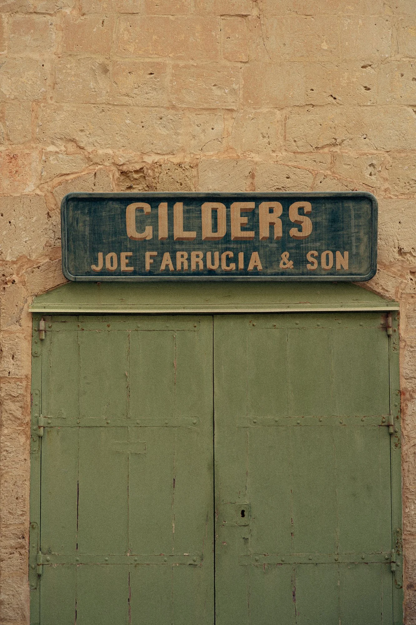 Vintage sign above a green door, heritage facade detail for design-led hotels and slow travel storytelling