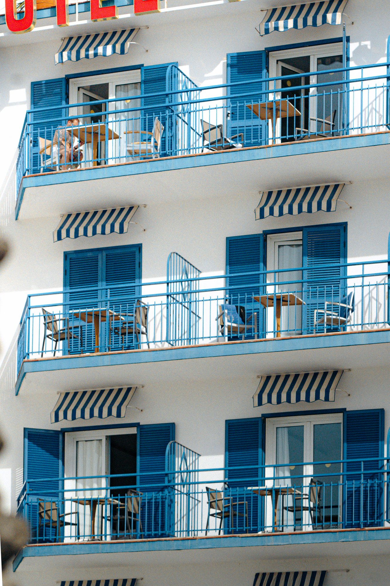 Mediterranean building with blue balconies, architectural pattern for design hotels and coastal stays content