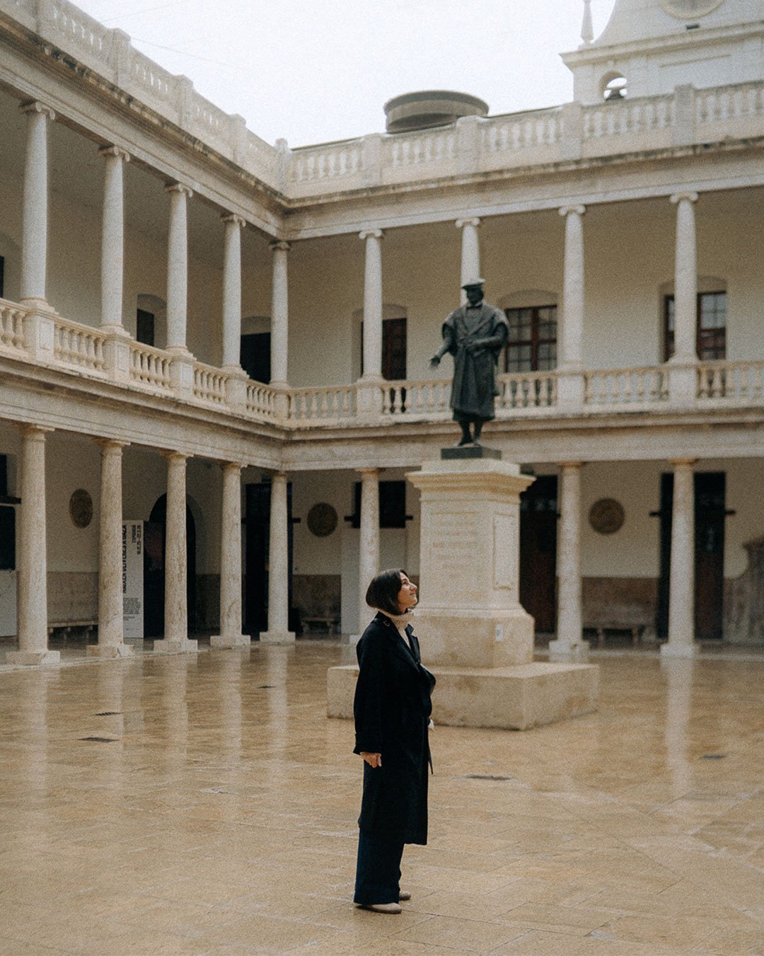 Elegant courtyard with arches and statue, timeless architecture scene for boutique hotels and cultural stays