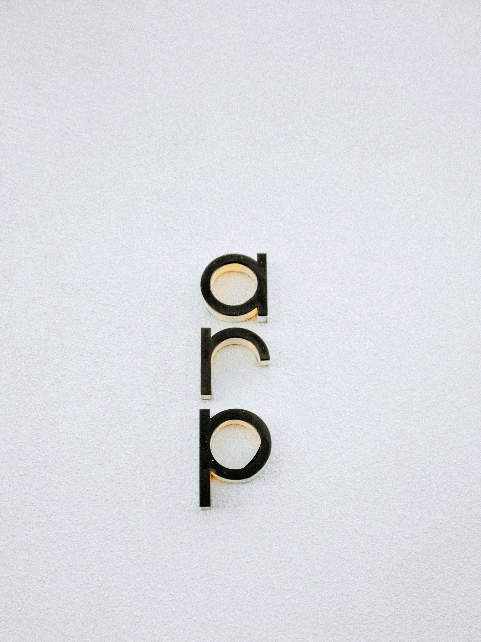 Imagen de letras 'abc' en una pared blanca con fondo de textura. Las letras son color negro con relleno blanco y tienen un diseño moderno.