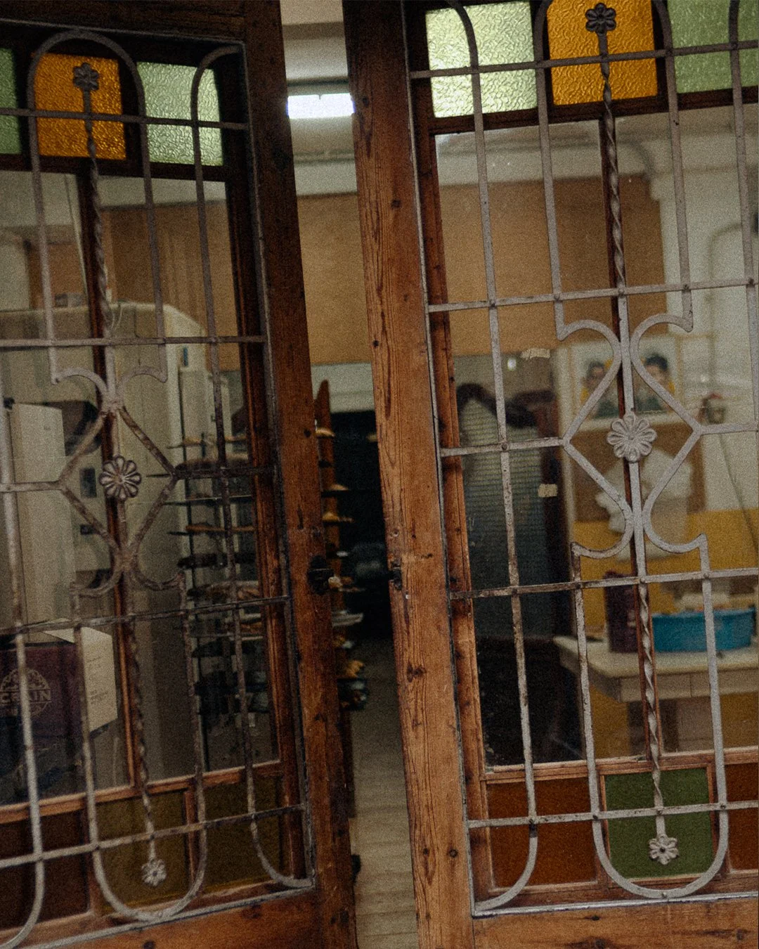Traditional wooden and wrought iron door with stained glass panels at Horno El Reloj bakery in El Cabanyal, Valencia