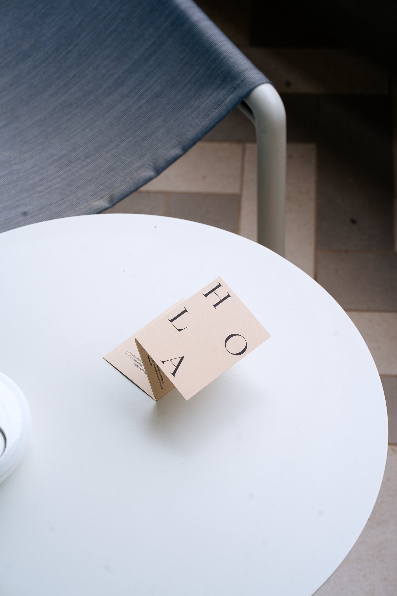 Minimal white table still life with a small object, clean editorial aesthetic for boutique hotel branding