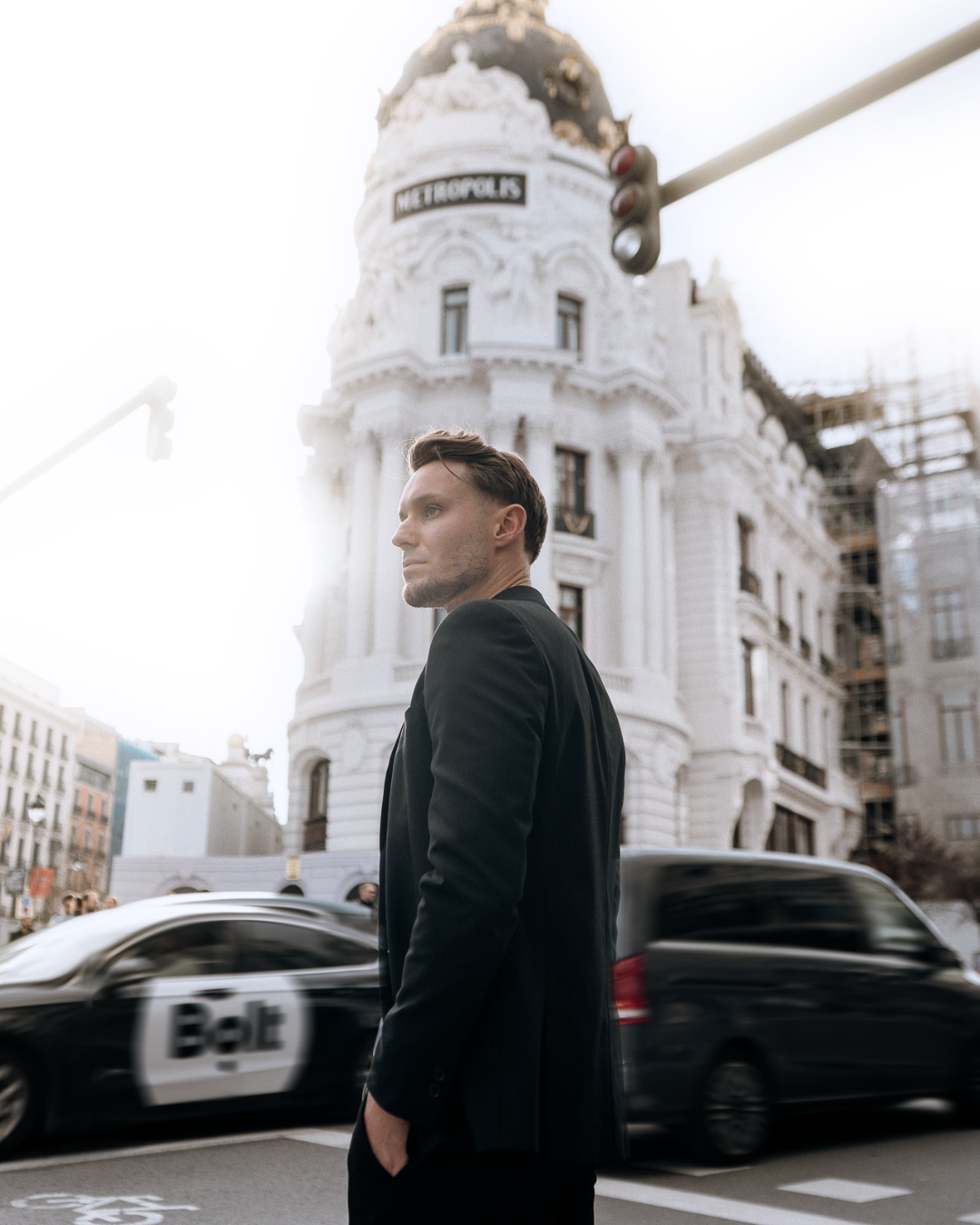 Man in a city street with classic architecture behind, lifestyle portrait for luxury hospitality and boutique stays in Madrid