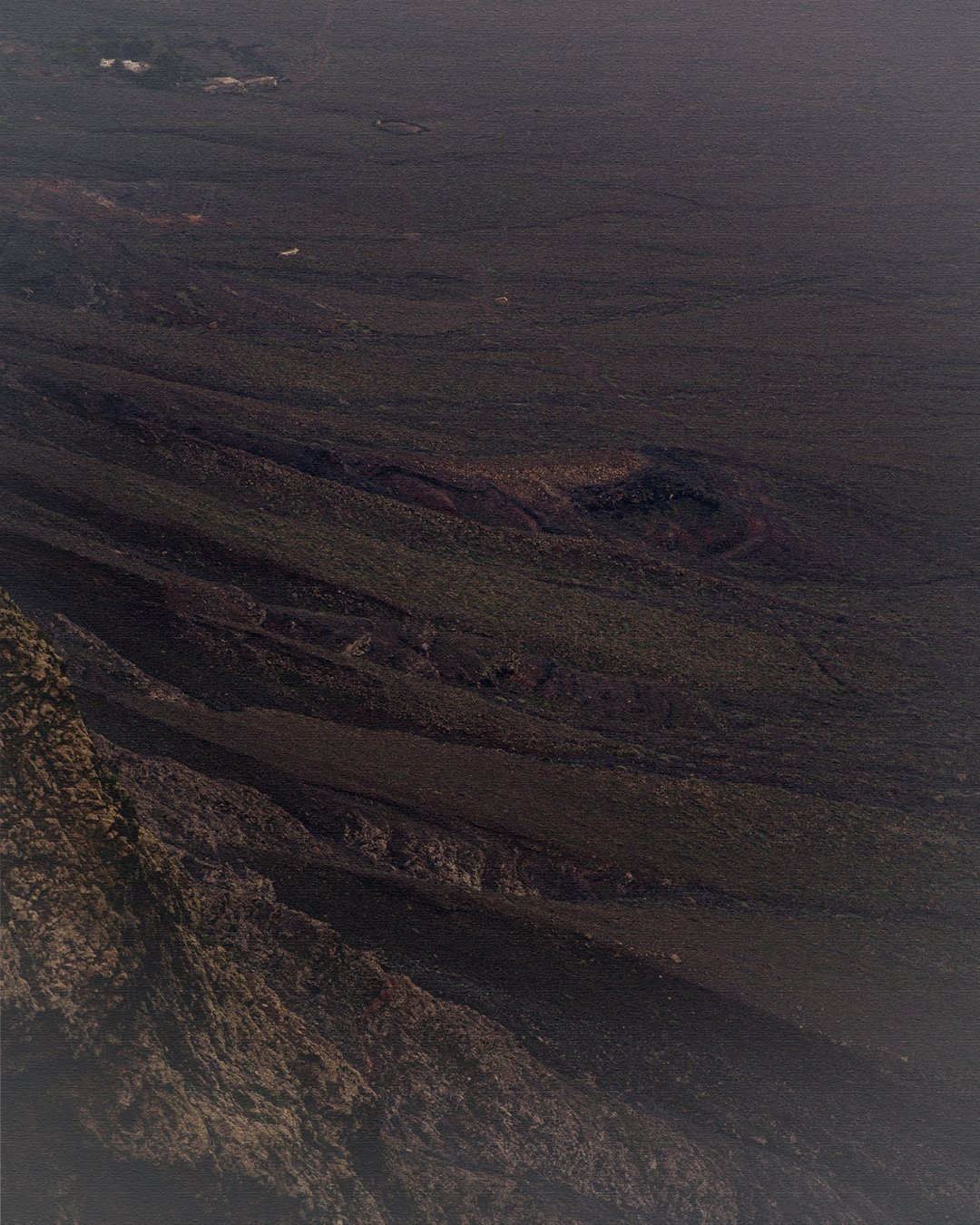Dark volcanic sand texture close-up, minimalist landscape detail for design hotel and slow travel branding in Lanzarote Spain