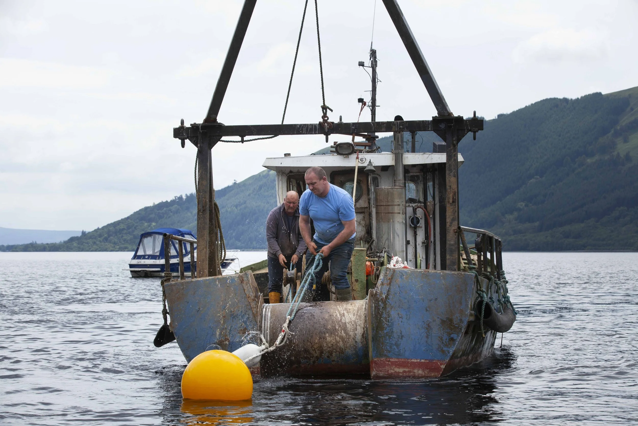 Two men working on a work boat in Loch Lomond