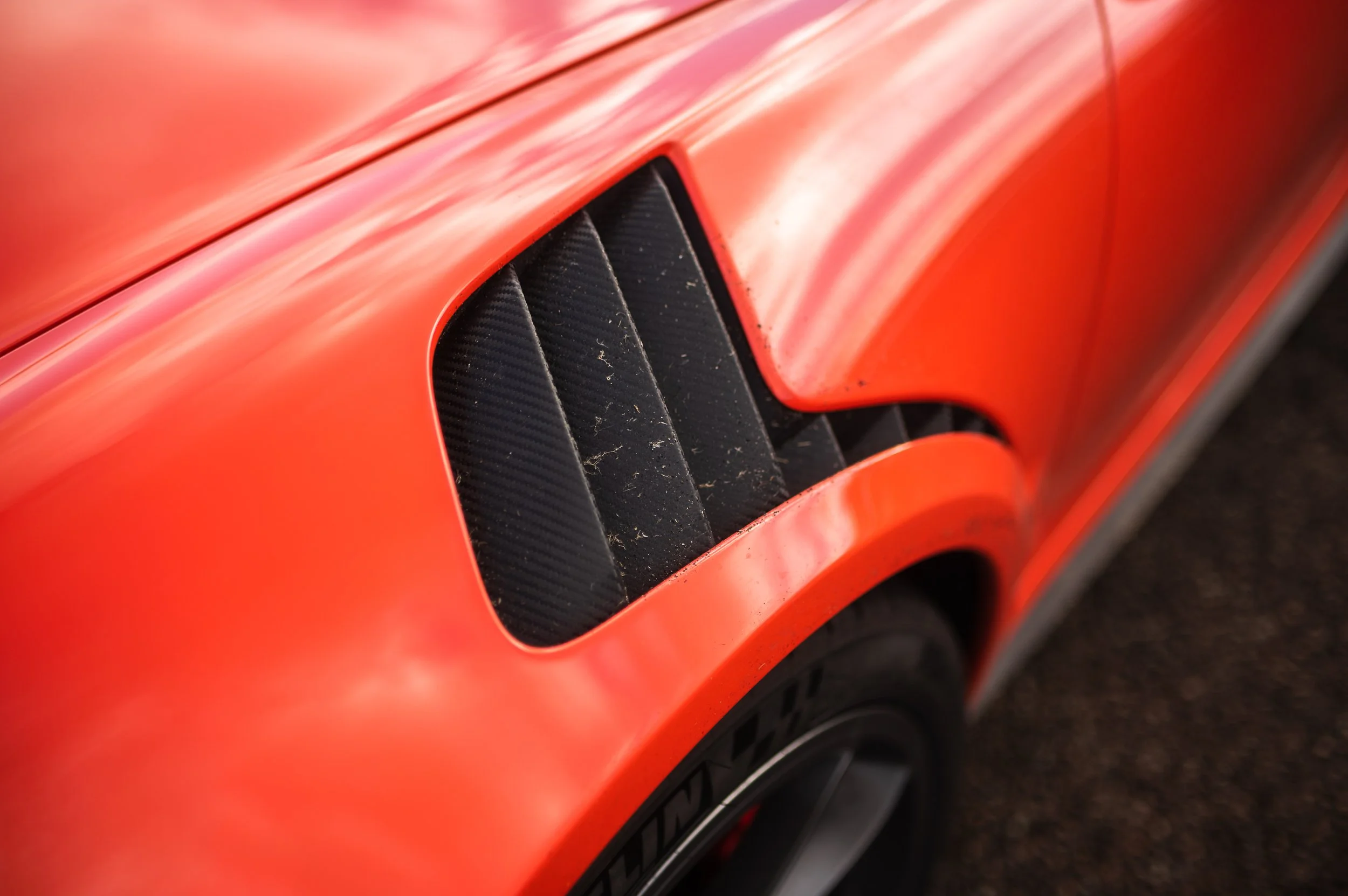 Close-up of a Porsche 911 (991.1) GT3RS with black accents and a tire visible at the bottom.