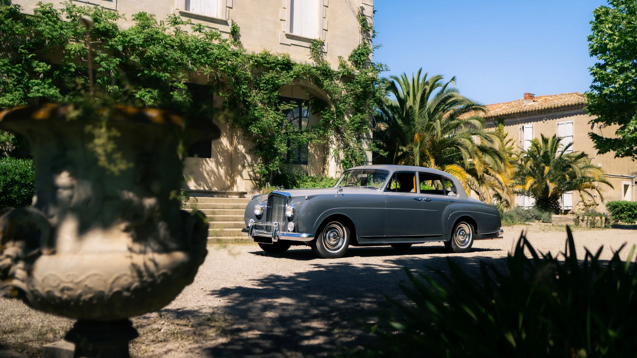 A 1958 dual-tone gray Bentley Mulliner S1 parked in front of a private Mansion in the South of France.