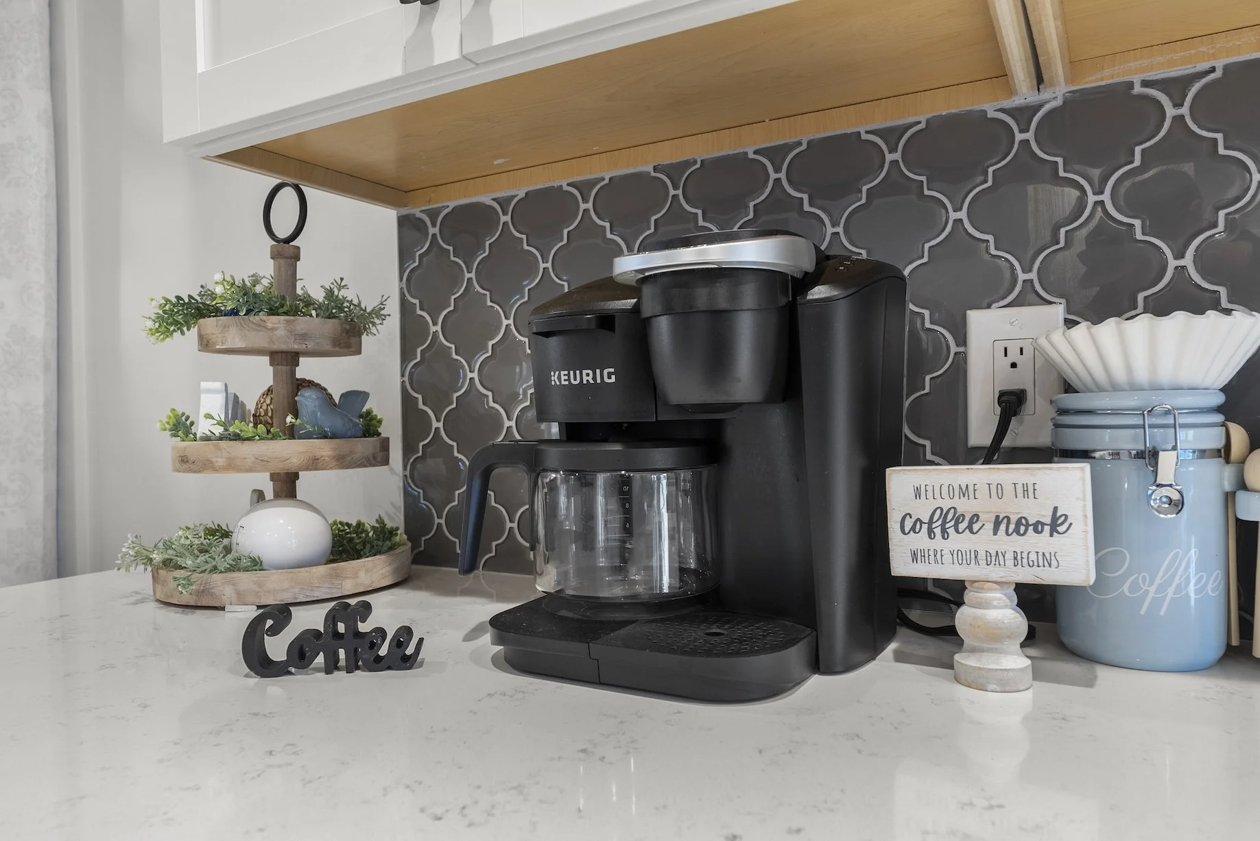 Cozy kitchen coffee station with a Keurig, open shelving, and classic tile backsplash in a welcoming Ball Ground, GA short-term rental.