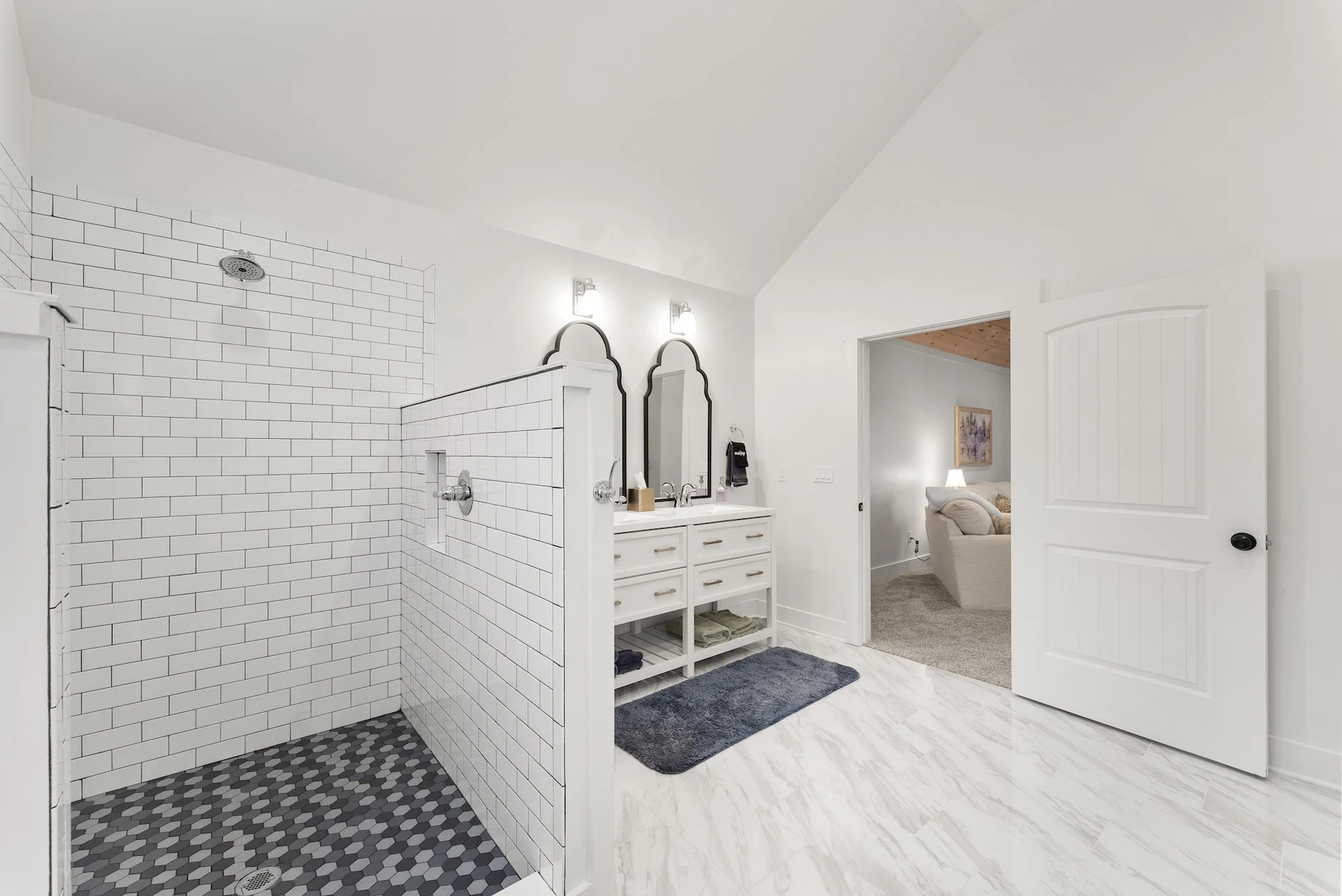 Clean and spacious bathroom with a walk-in shower, bright white finishes, and a doorway leading to the bedroom at a Ball Ground, GA short-term rental.