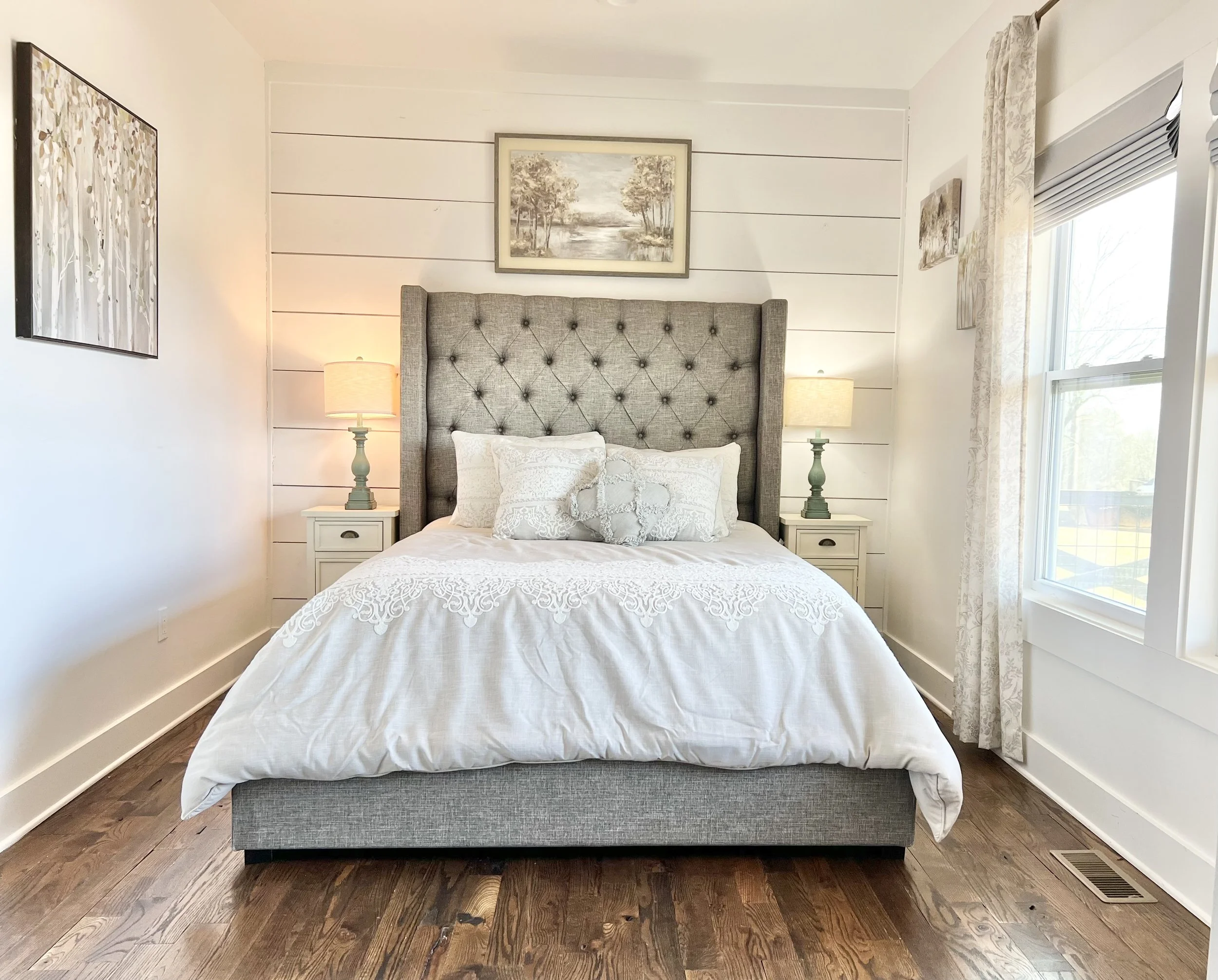 spacious queen bedroom with a tufted headboard, crisp white bedding, and soft neutral decor in a peaceful Ball Ground, Georgia vacation rental.