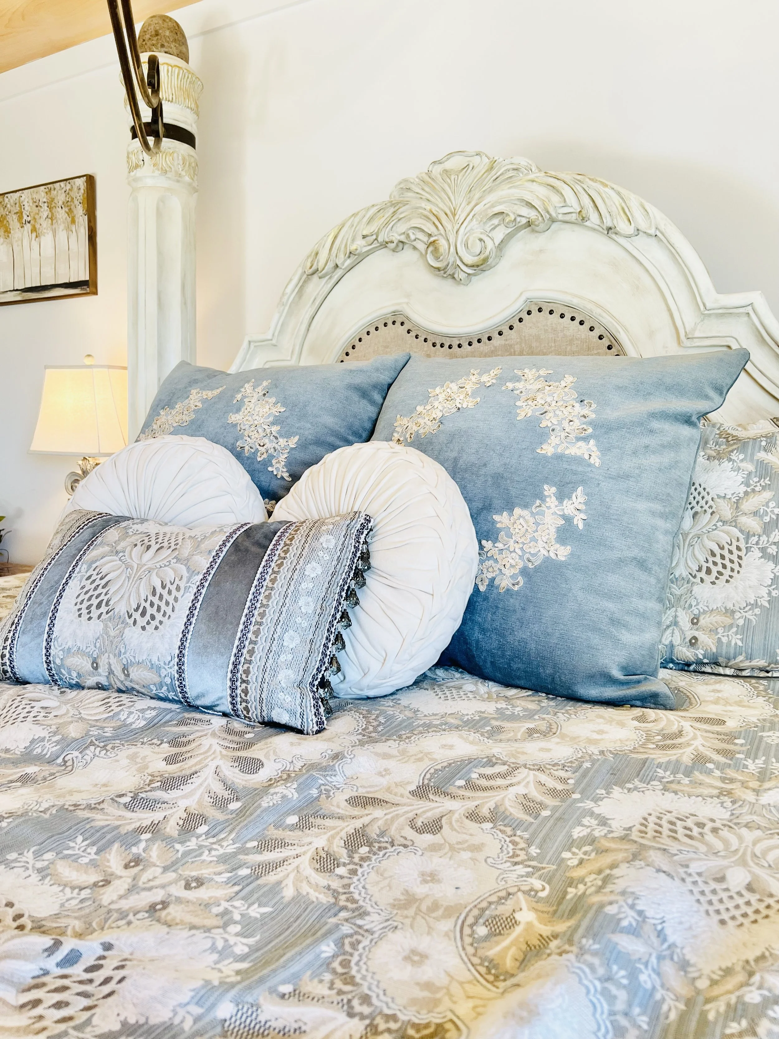 Close-up of layered blue and neutral bedding with decorative pillows in a cozy French country–style guest bedroom at a Ball Ground, Georgia vacation rental.