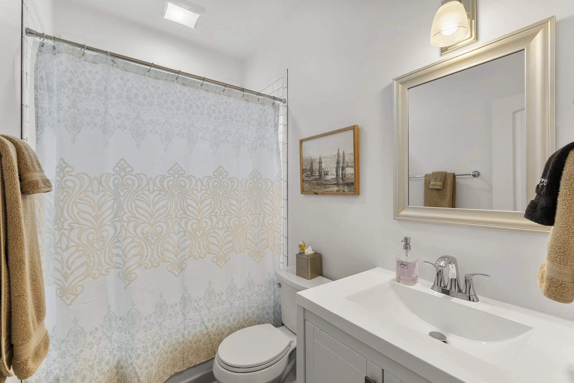 Clean and bright bathroom with a shower, large vanity mirror, fresh towels, and classic finishes at a Ball Ground, Georgia vacation rental.