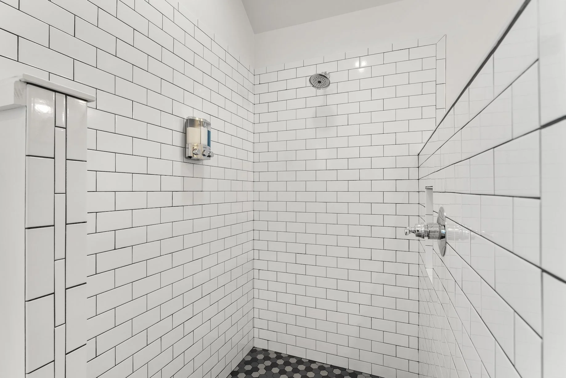 Spacious walk-in shower with white tile walls and modern fixtures in a clean Ball Ground, GA short-term rental bathroom.