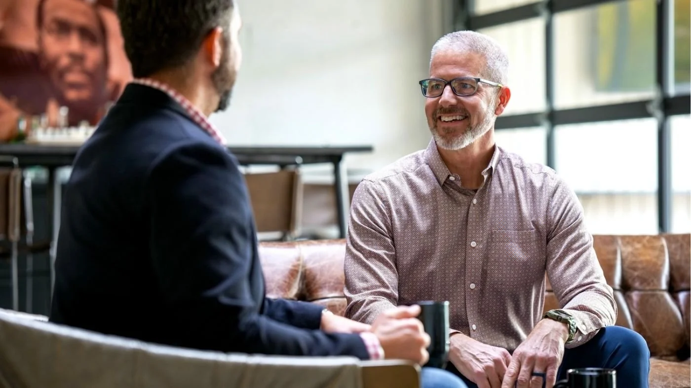 A photo of business owner Preston True communicating with an employee to build team trust.