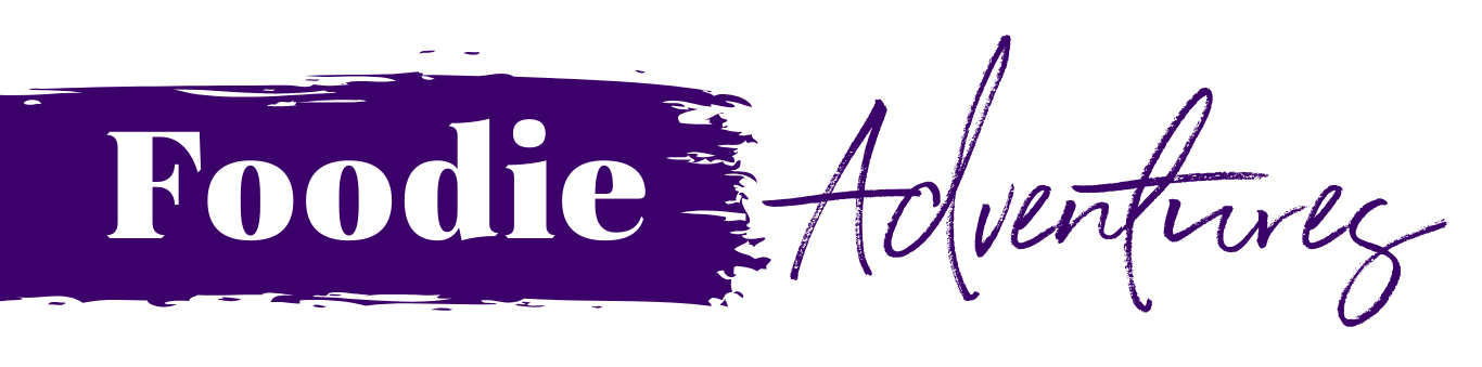 Text logo reading 'Foodie Adventures' with 'Foodie' in bold white font on a purple background and 'Adventures' in purple cursive script.
