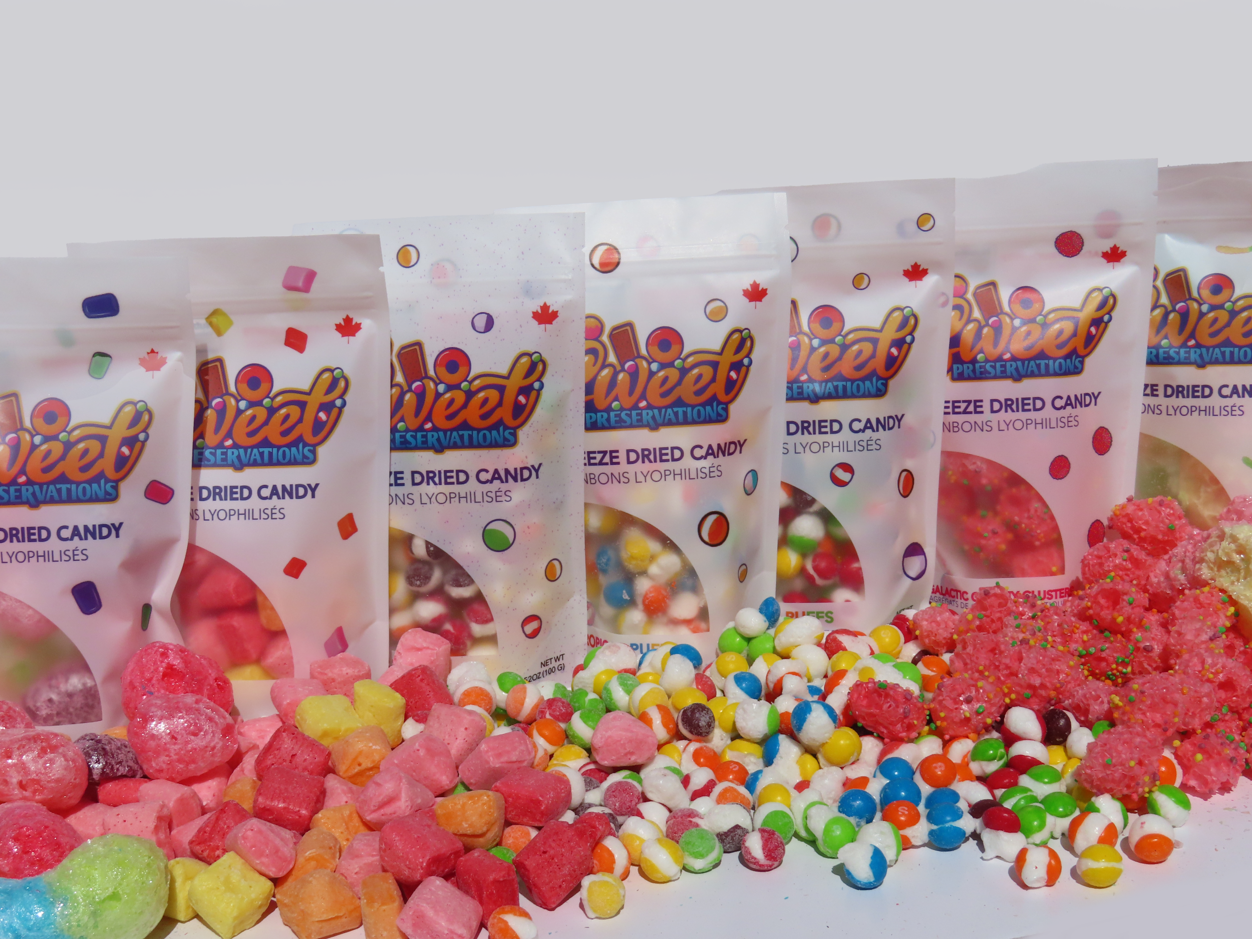 Multiple colorful packages of Veet preservation dried candy with scattered assorted candies in front.