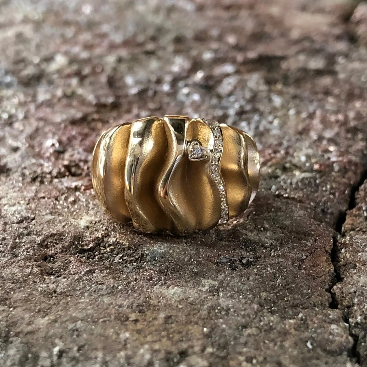 Smyckesring i guld med organisk form och infattade diamanter, tillverkad av Guldsmedshuset, Anemone.