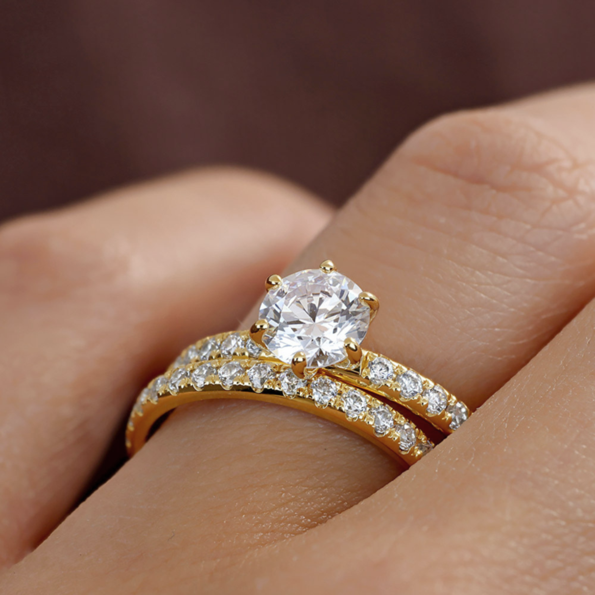 Enstensring med diamant tillsammans med alliansring i gult guld på hand.