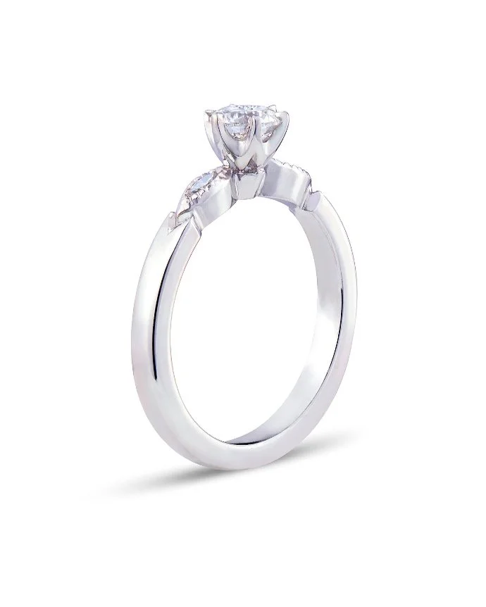 Novalie enstensring i vitguld med diamant och milligriff vid de navettformade sidodetaljerna, formgiven och tillverkad i Guldsmedshusets egen verkstad.