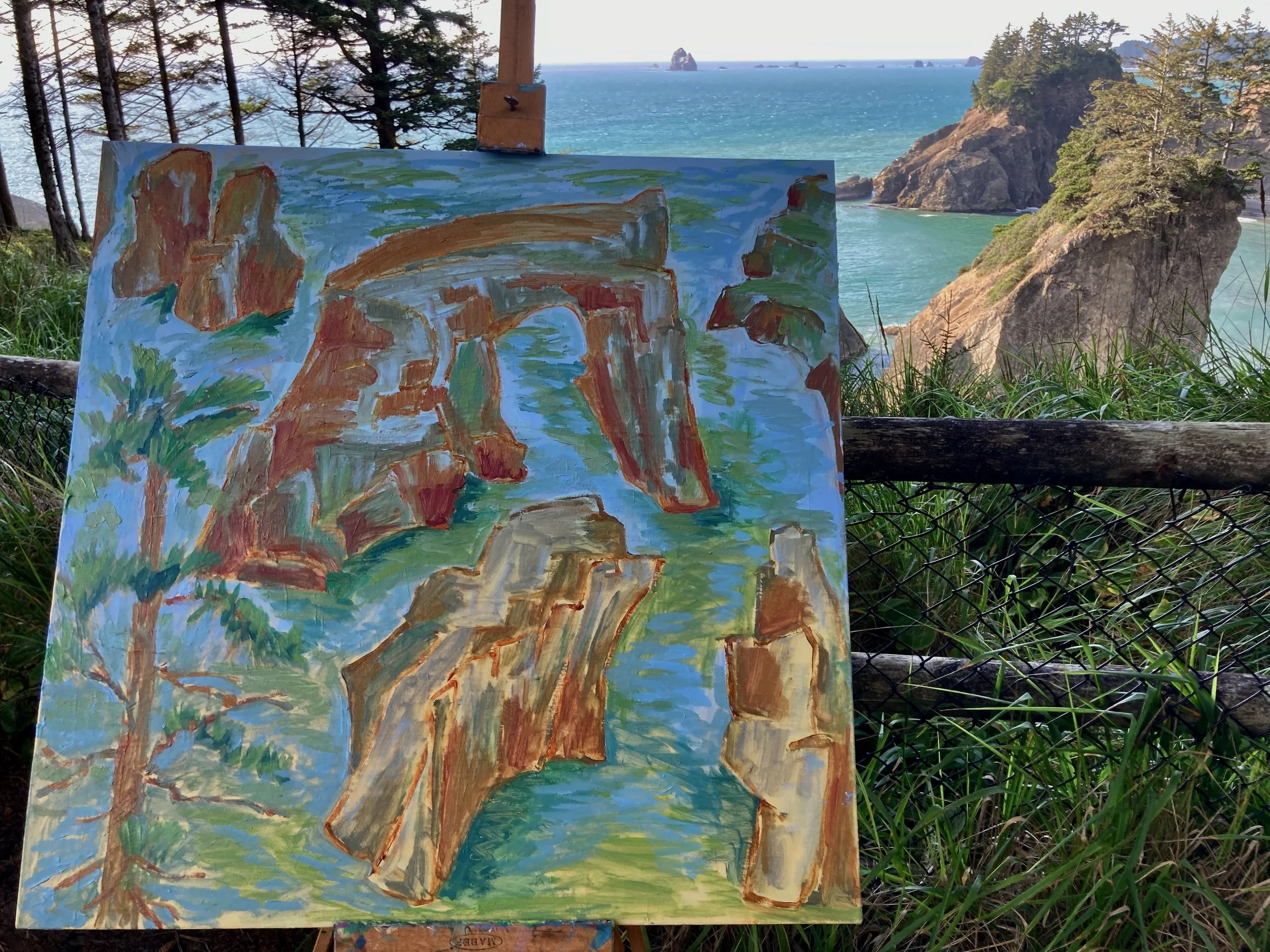 A painting of a landscape with cliffs, trees, and water, set against the actual scene of a rocky coastline with ocean and island in the background.