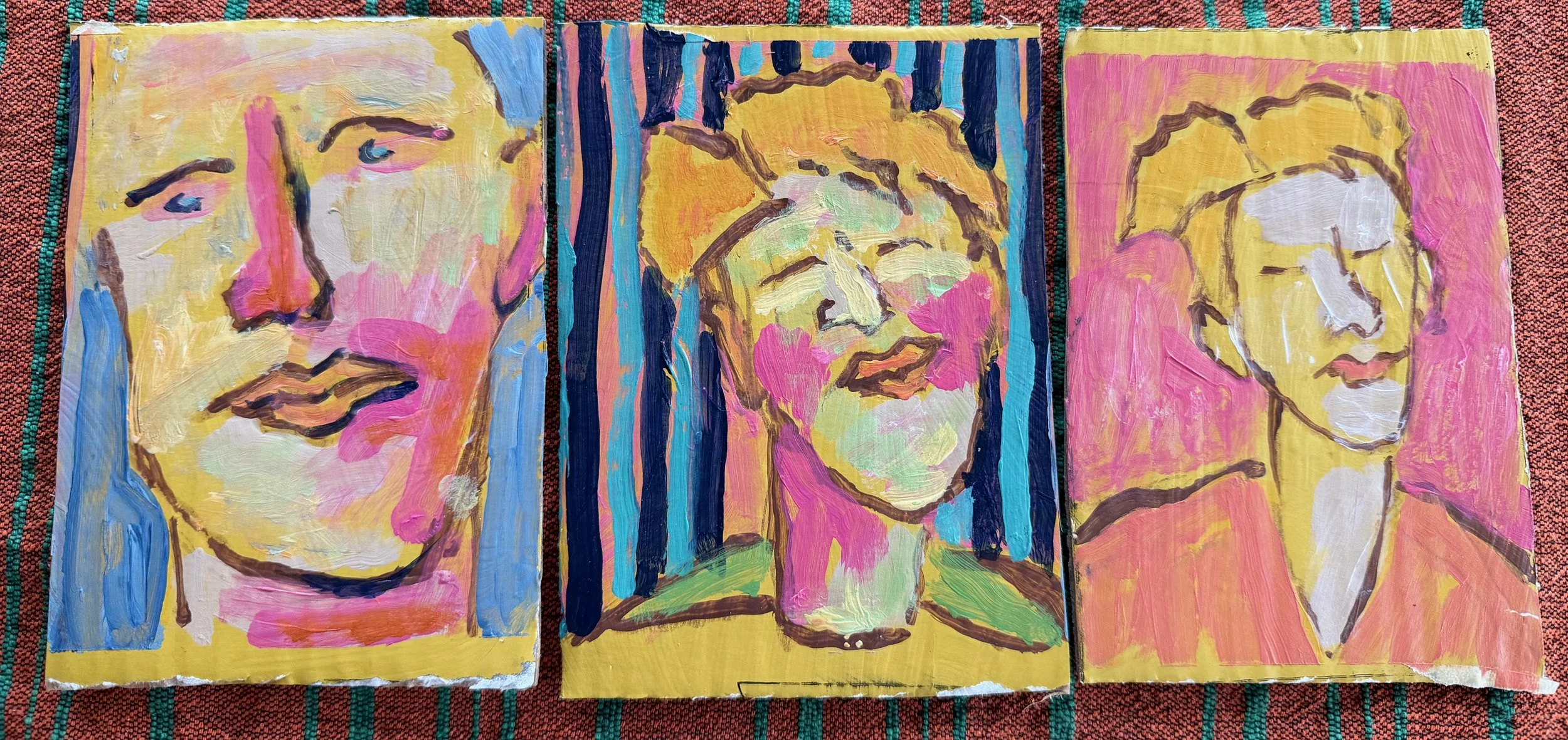 Three colorful abstract paintings of female faces on small canvases, displayed side by side.