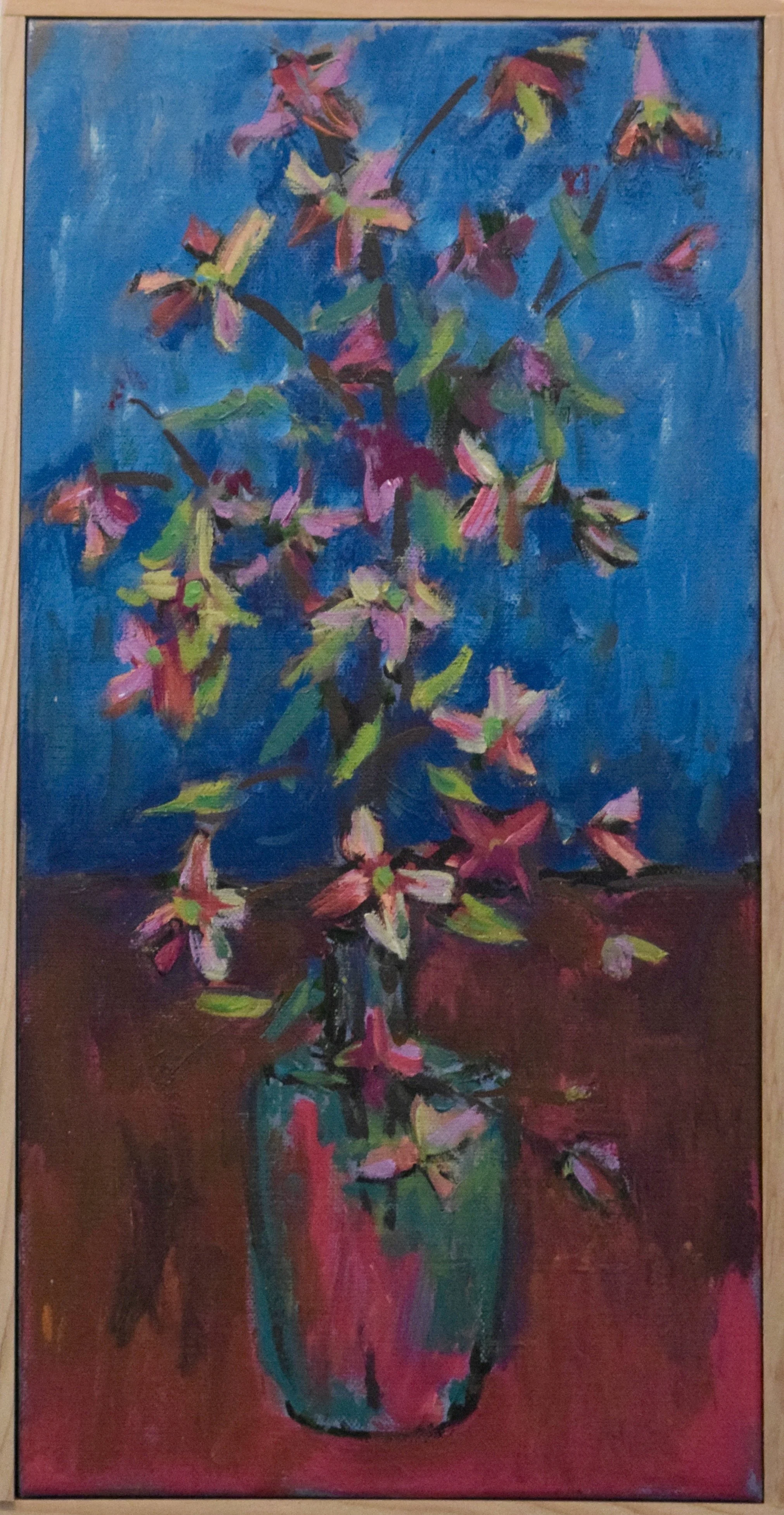 Impressionist painting of pink and white flowers with green leaves in a red, green, and black vase on a dark surface against a blue background.