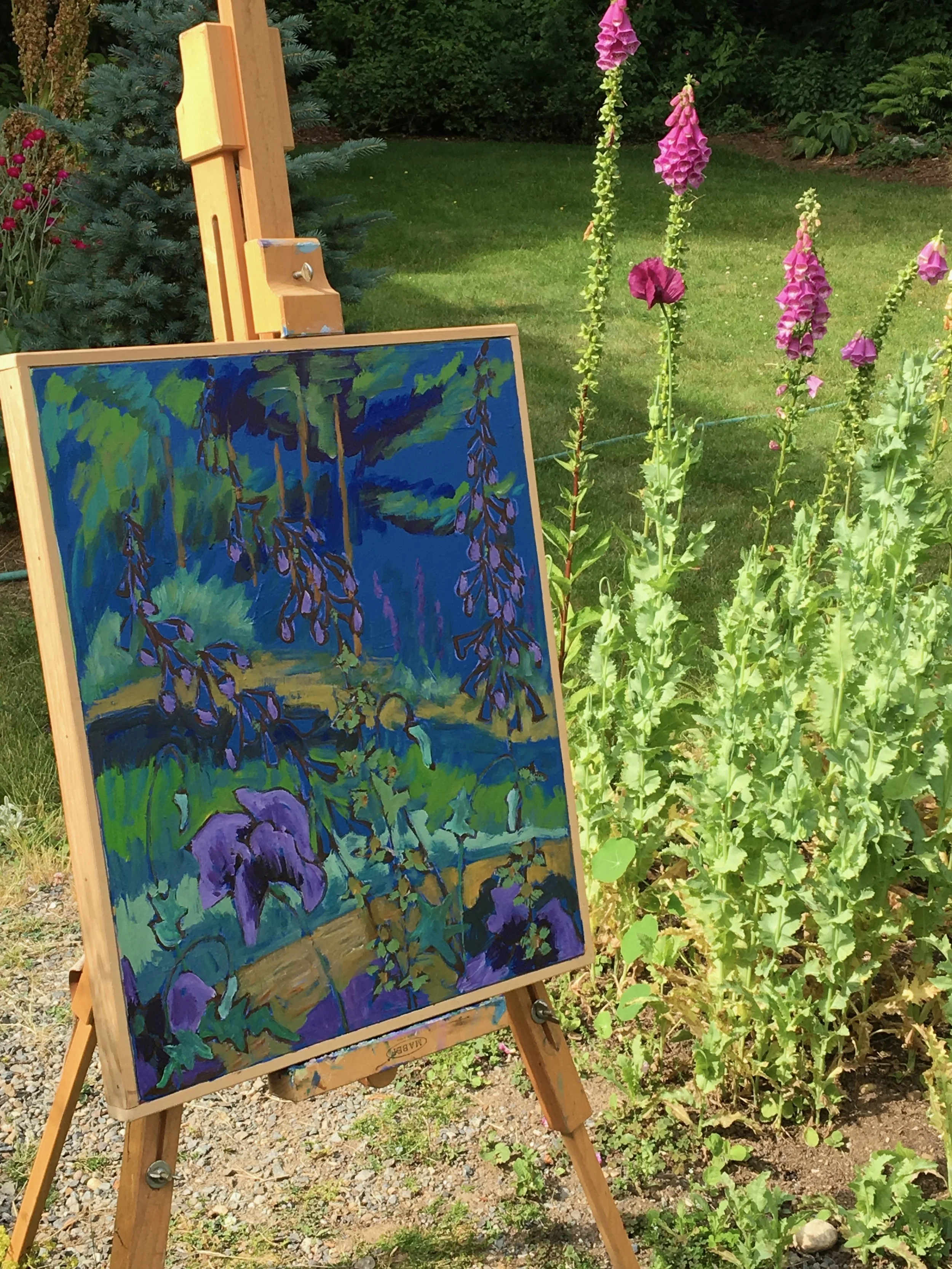 An easel holding a painting of tall purple flowers, set in a garden with pink flowers and green foliage in the background.