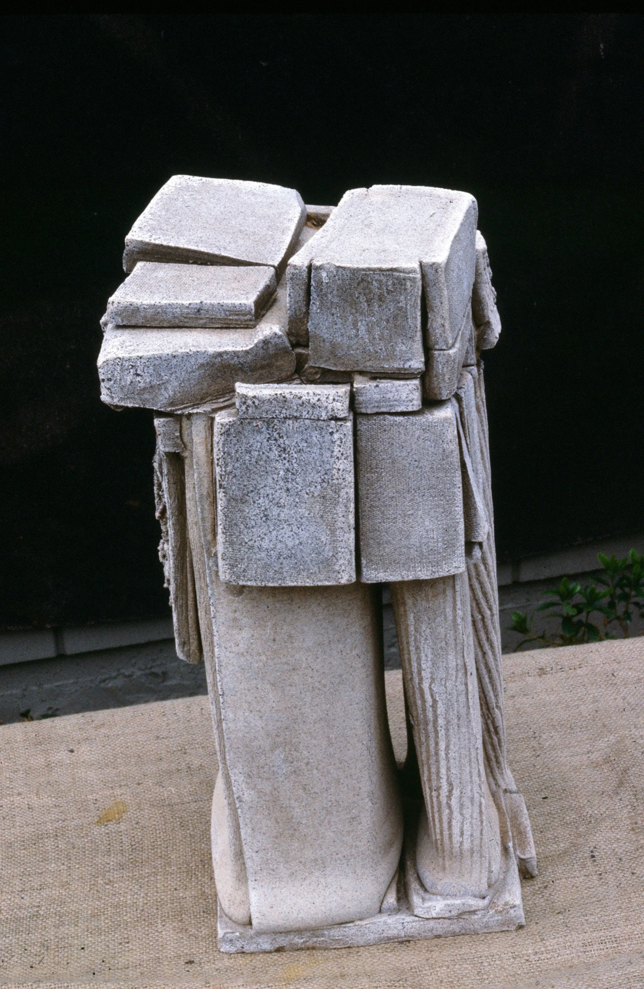 Ancient stone sculpture and fragments of carved stone blocks against a dark background.