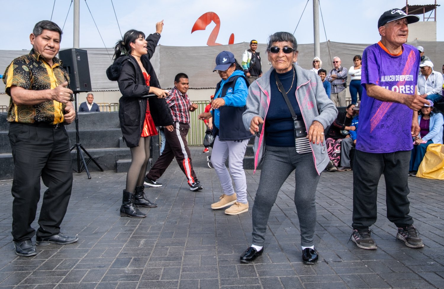 People dancing and socializing outdoors at a public event or gathering.