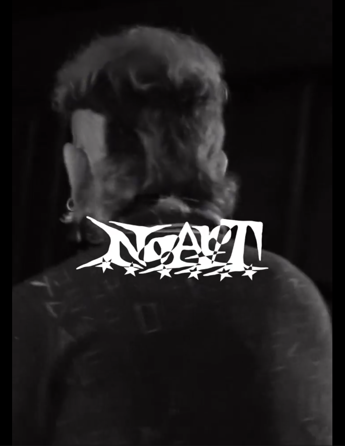 Retrato en blanco y negro de una persona vista desde atrás, con cabello rizado y un peinado estilo moño, con una camiseta con remaches o costuras en la espalda, y un logo en el centro que dice 'NACHT' con estrellas bajo del texto.