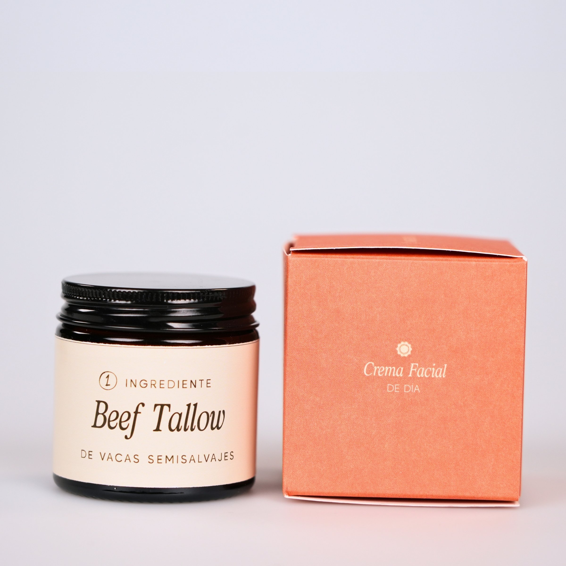 Frascos y caja con productos para el cuidado facial, uno con etiqueta que dice 'Beef Tallow' y otro con caja que dice 'Crema Facial de Día'.