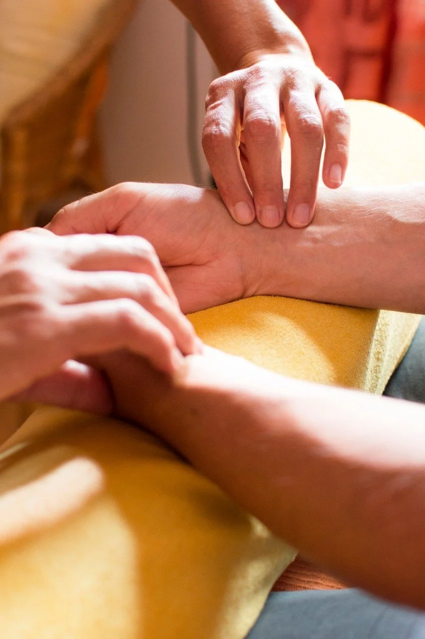 Hände tasten einen Puls am Handgelenk