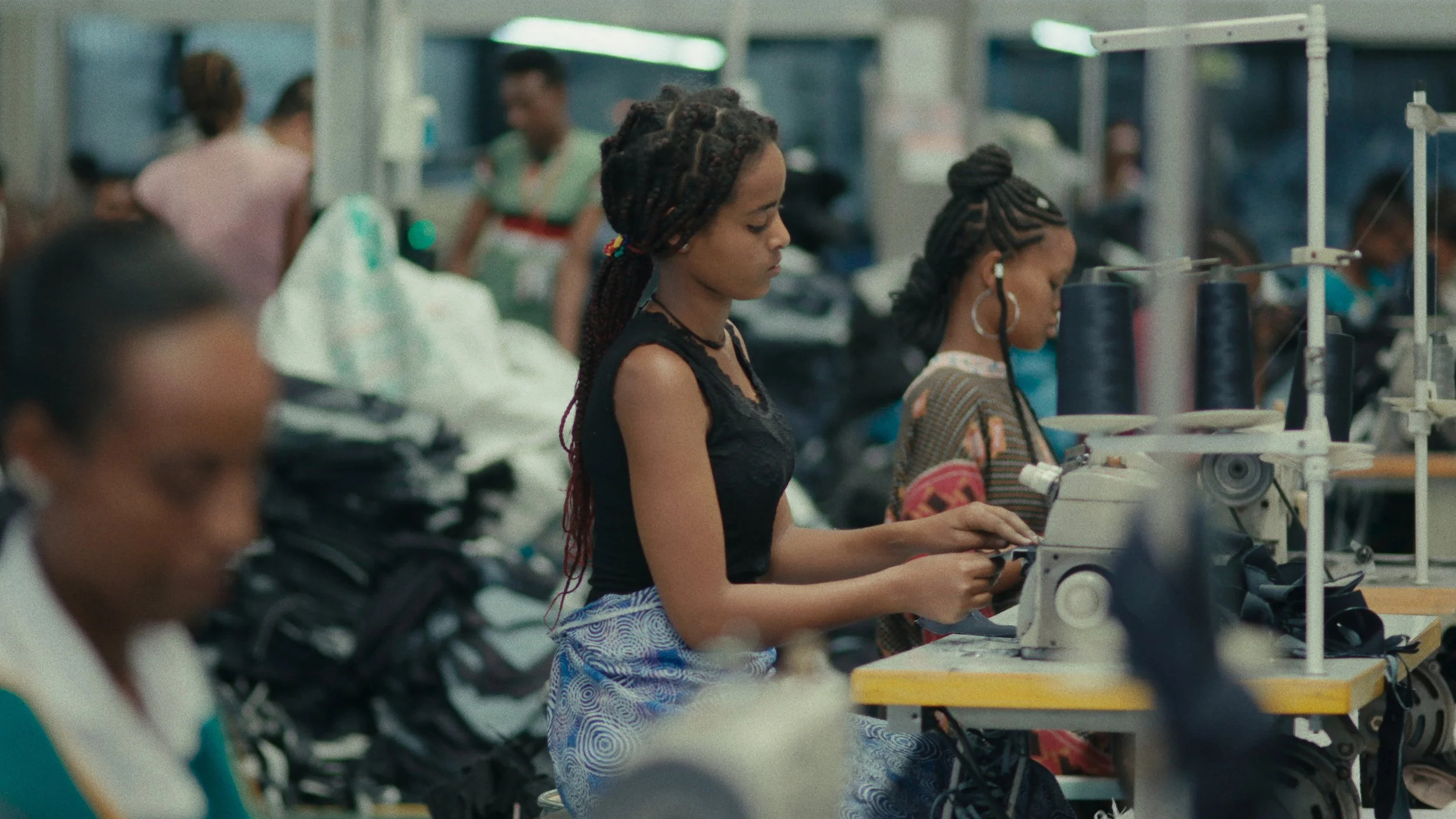 Women working at sewing machines in a factory setting.