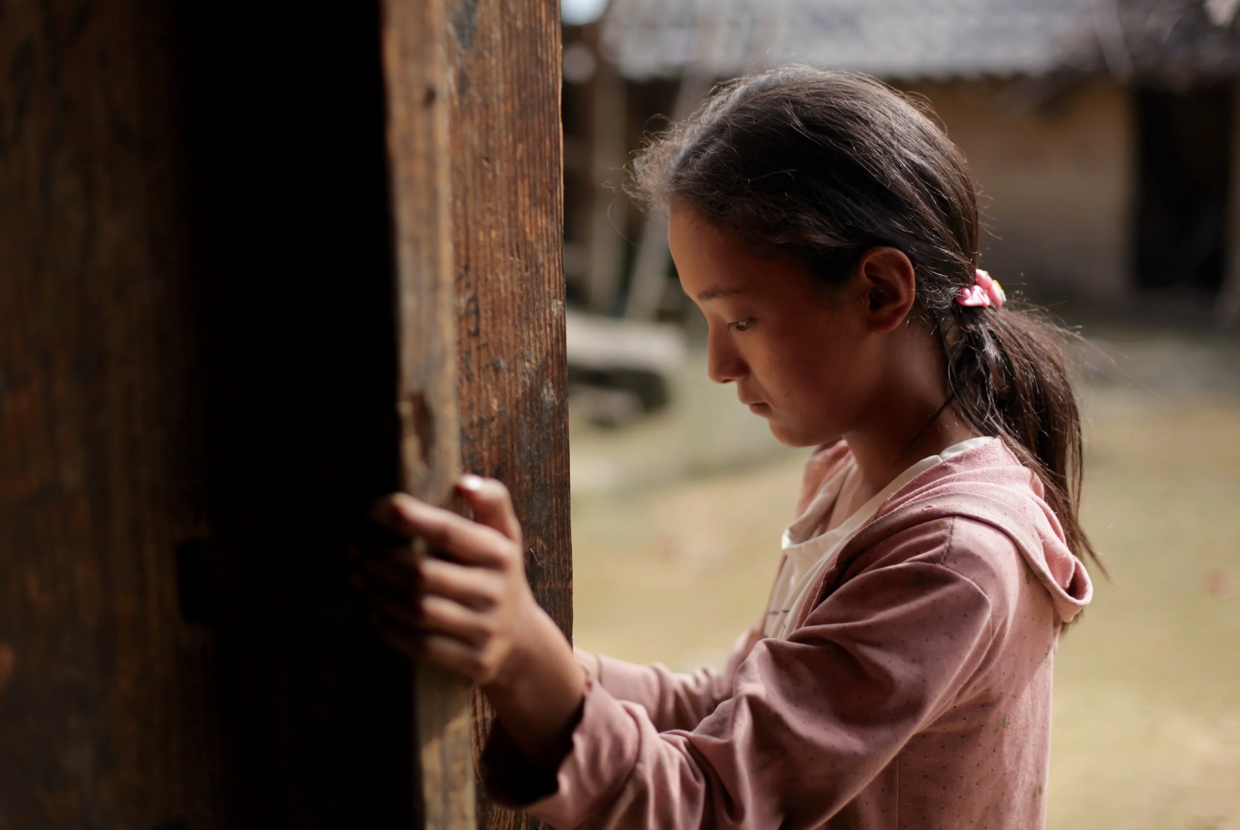 Twelve-year-old Wang Bing stands by the door of her family's farmhouse in Liangshan prefecture, Sichuan province, China, July 2016 (1).jpg