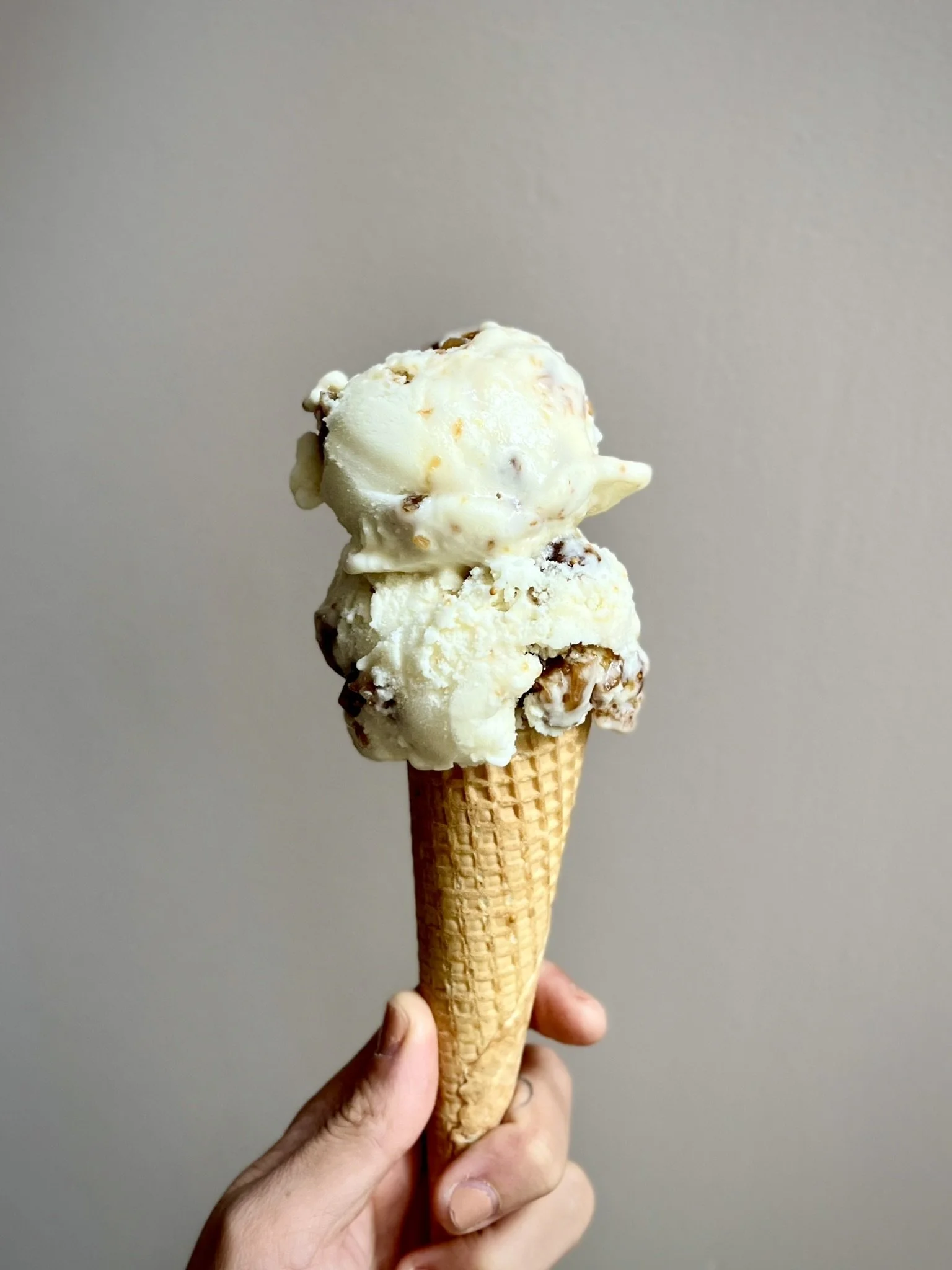 Hand die een ijsje vasthoudt in een waffle hoorntje