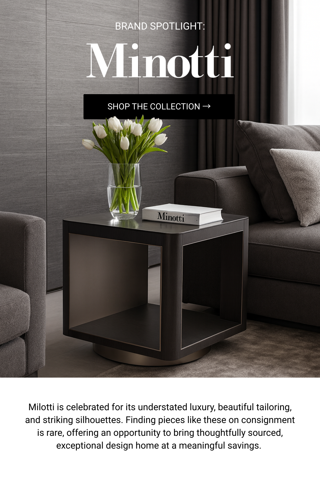 Interior of a modern living room featuring a side table with a vase of white tulips and a Minotti book, gray couches, gray walls, and dark curtains.