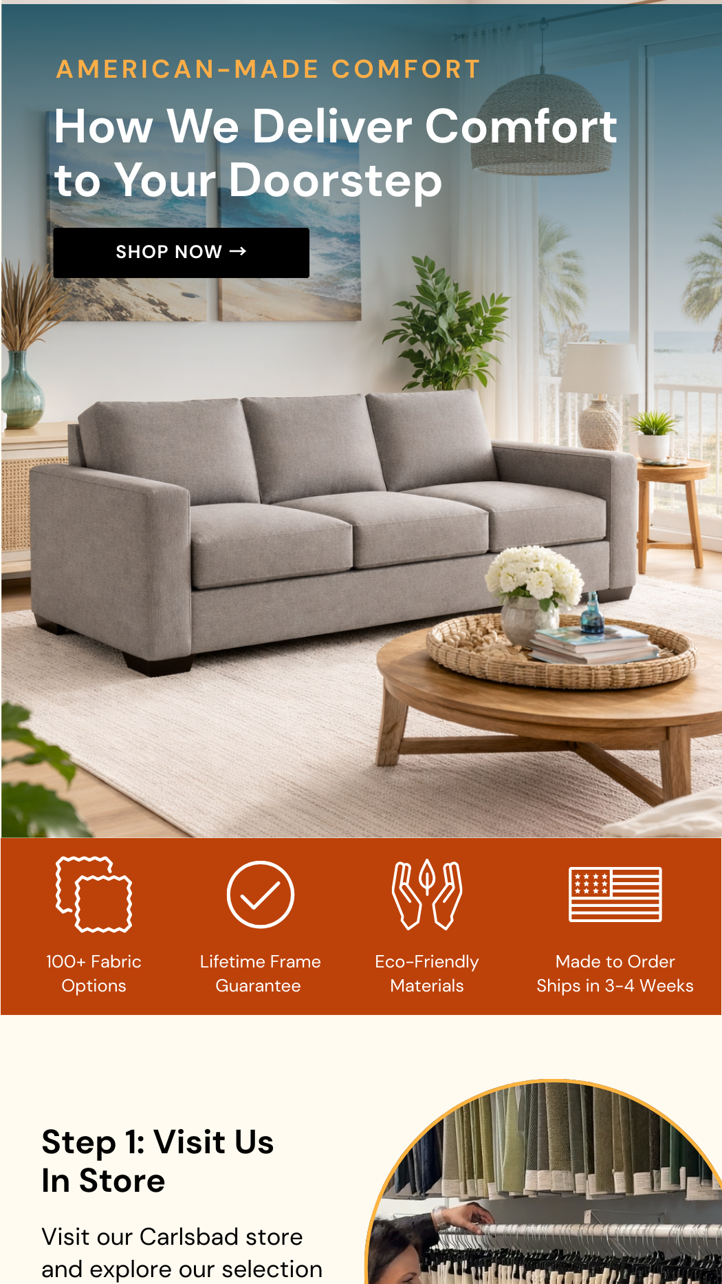 A living room with a gray sofa, a wooden coffee table with a flower arrangement and magazines, a potted plant, a lamp, and beach art on the wall, with large windows overlooking a beach scene.