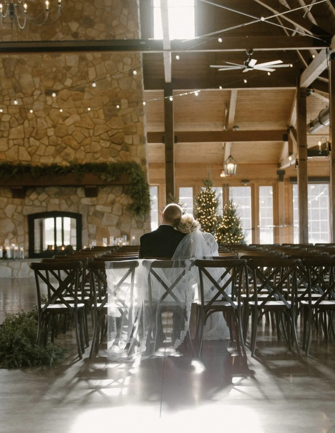 Delaney and her husband with their heads facing away from us, looking at their wedding venue with her head on his shoulder