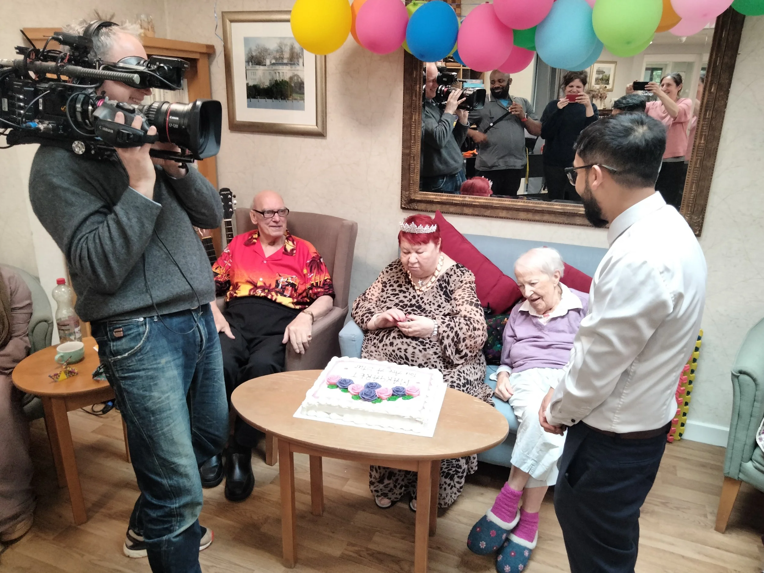 Two Friends Films is filming a party in a care setting.   Everyone is happy and enjoying themselves and the atmosphere is great.  It's for a Legacy Film, a Life Story film and also is a way of explaining your life to the next generation.